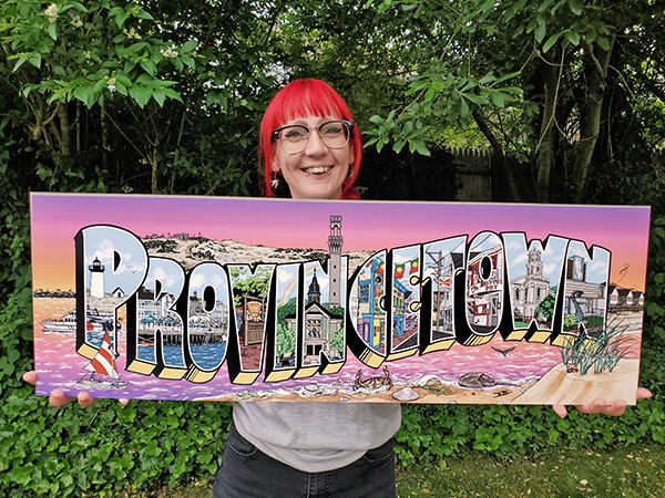 A photo of Kiki holding a print of her "Provincetown" illustration.
